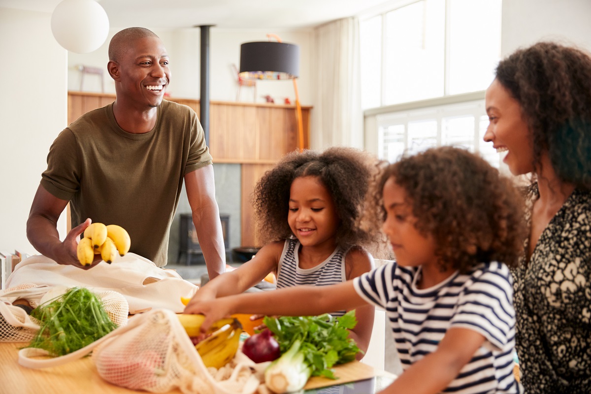 Smiling parents with two young girls in their kitchen
