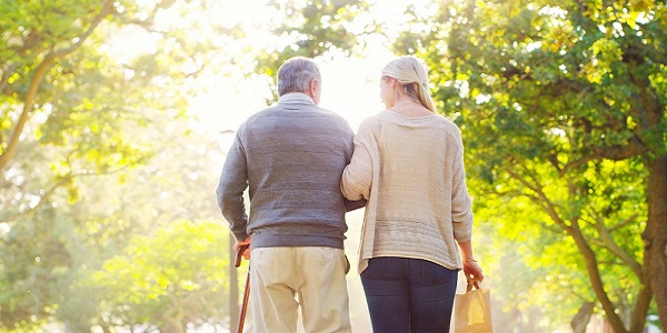 Senior man walking with daughter in a park