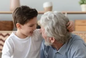 Happy little boy having fun with smiling grandfather
