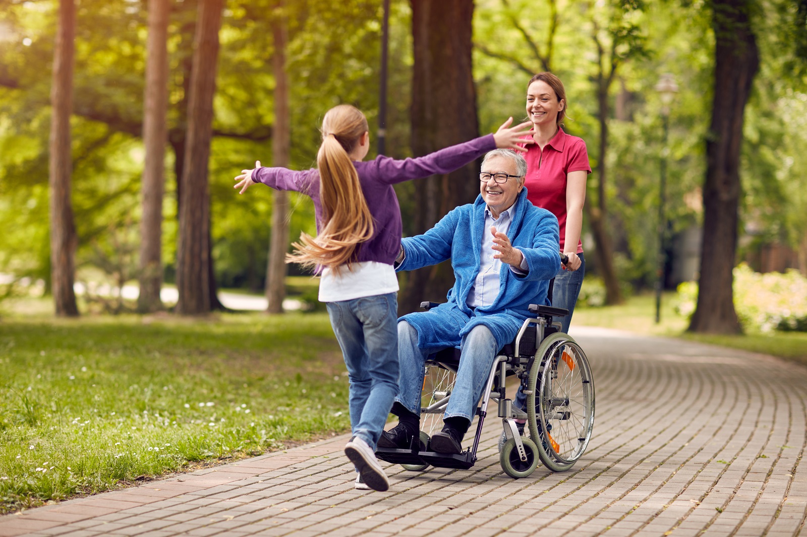 cheerful grandfather in wheelchair welcoming his granddaughter