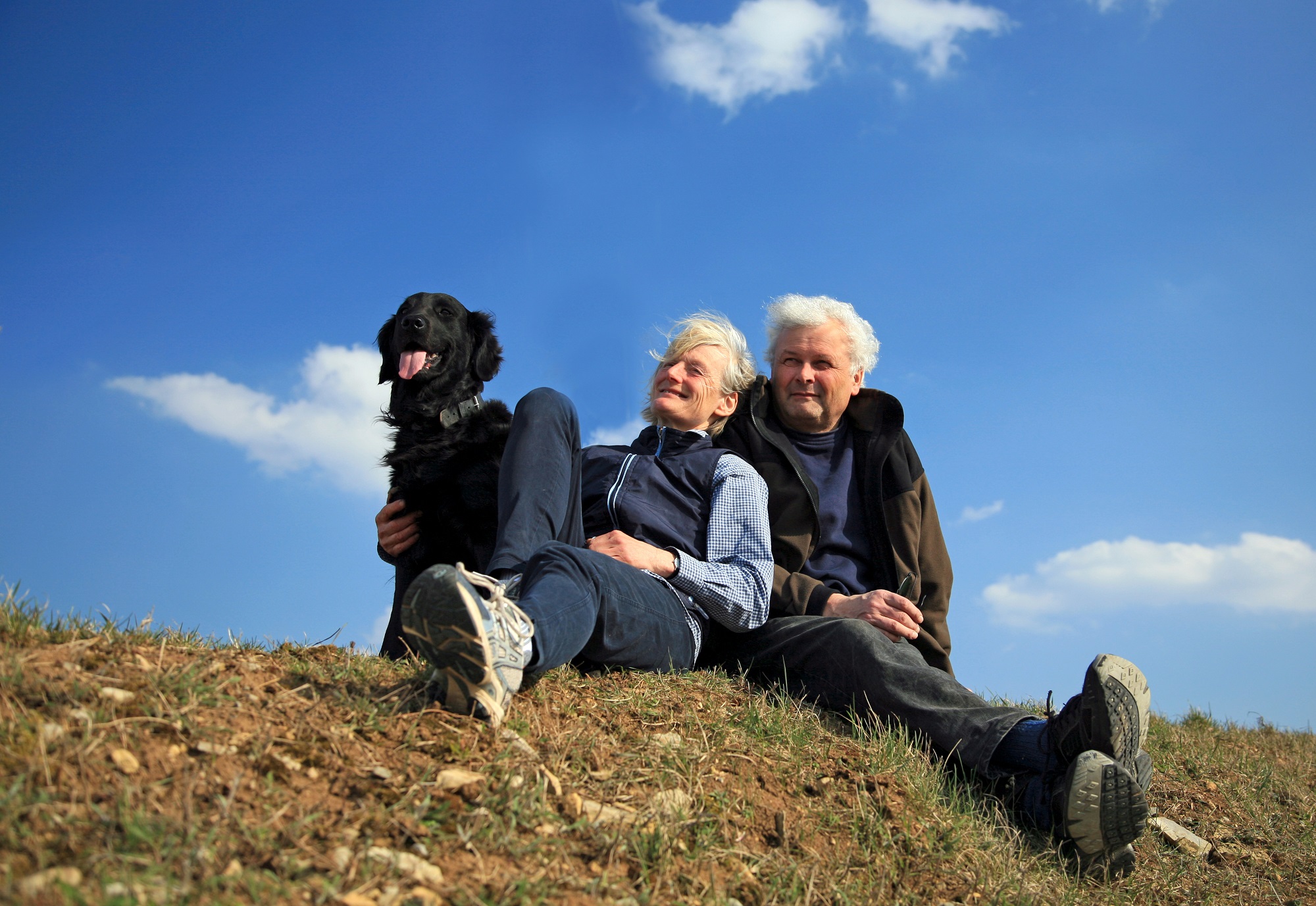 Happy elderly couple enjoying nature with their dog