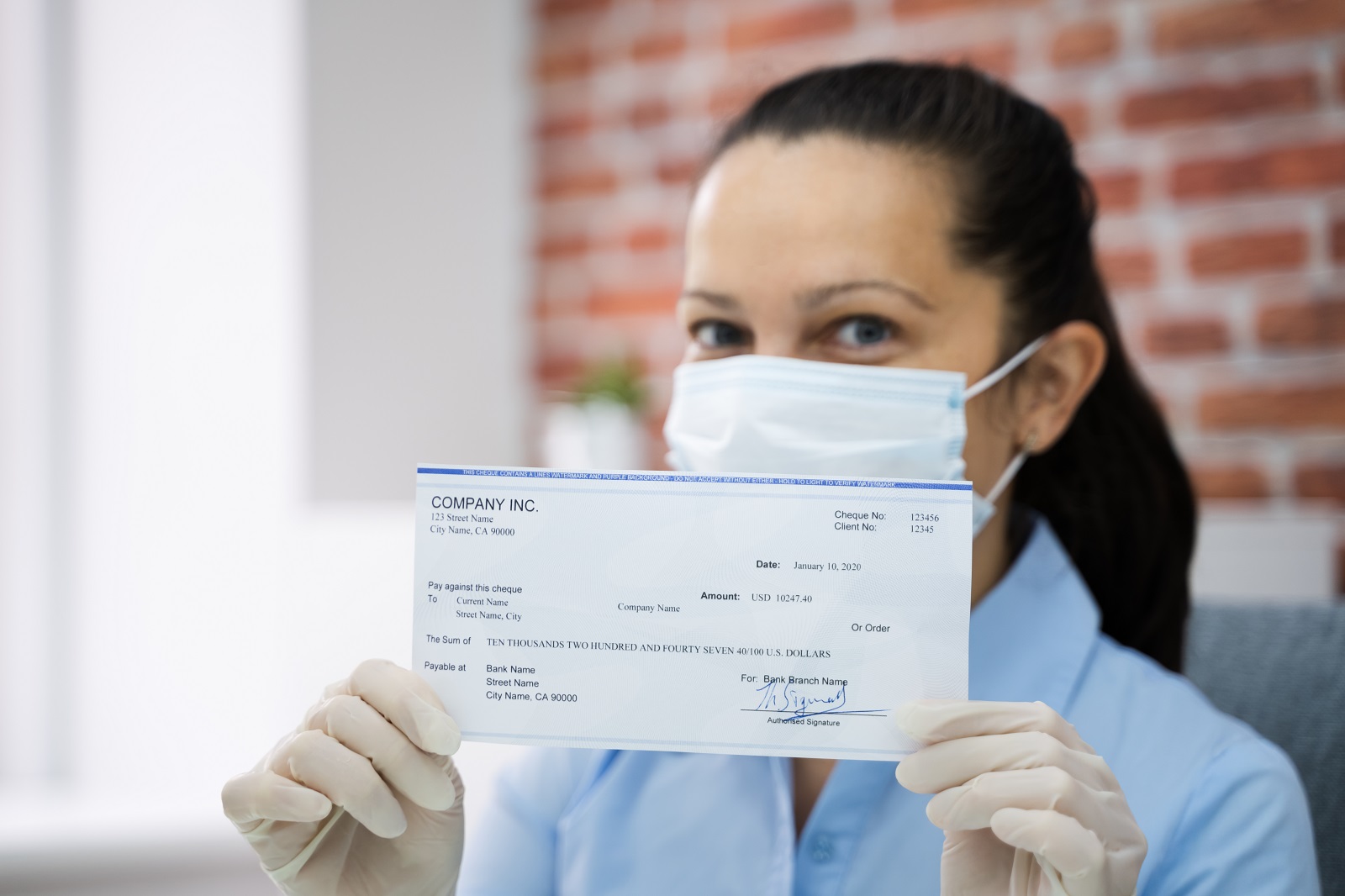 Woman In Face Mask Holding Stimulus Check