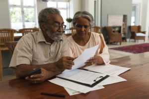 Senior man and woman in their home reviewing estate planning documents at a table