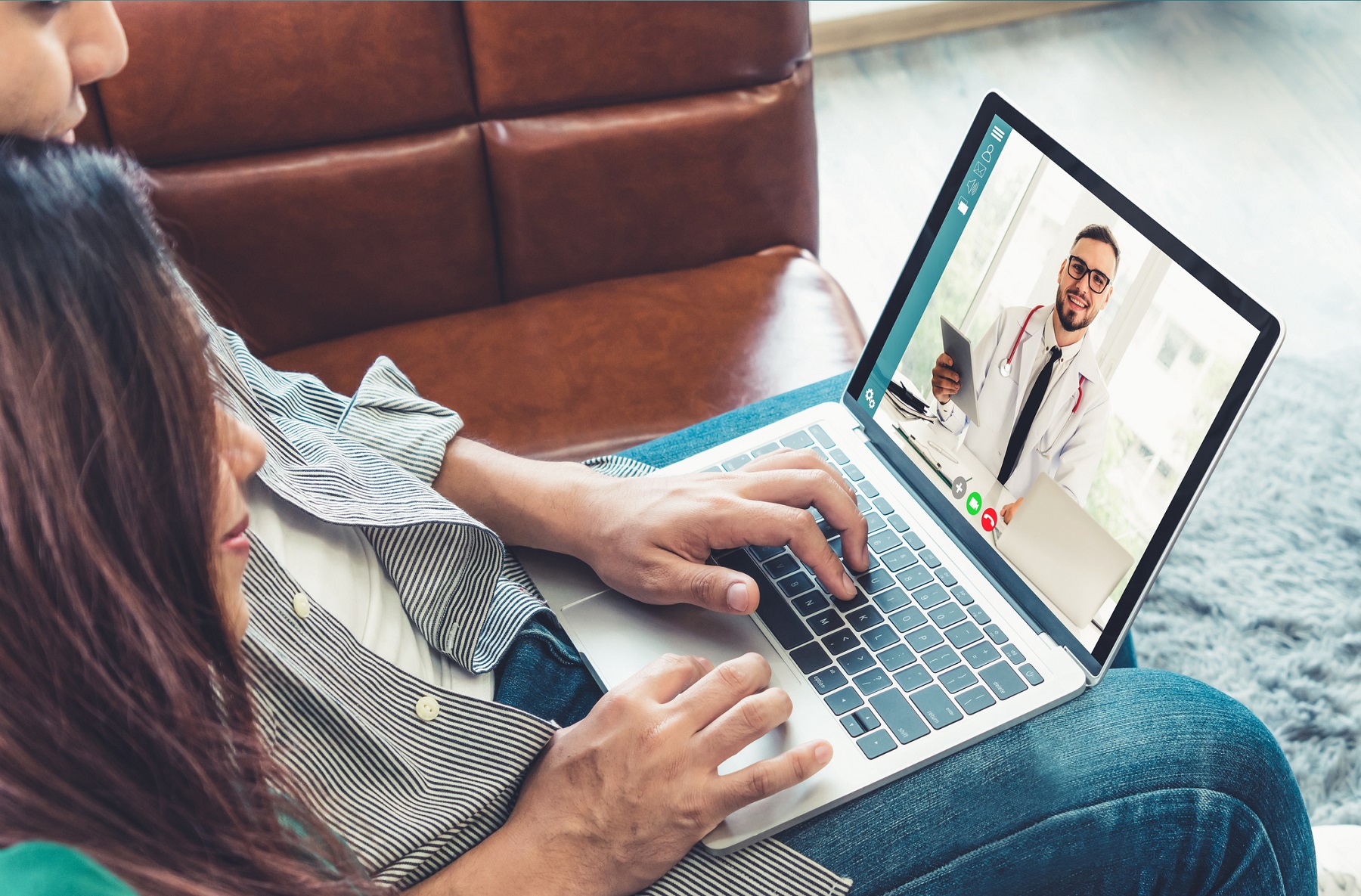 Man and woman at home having a Doctor online video chat.