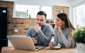 Couple at home with laptop managing finances