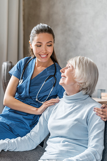 happy elderly woman with nurse at home