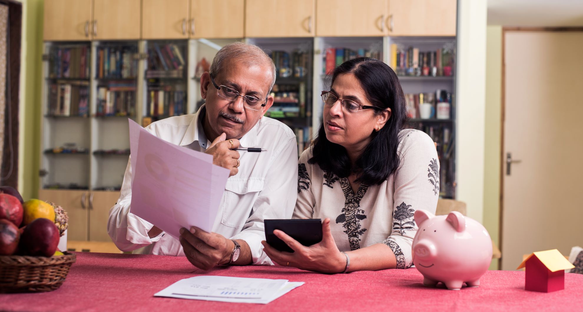 Two adults at home reviewing financial documents