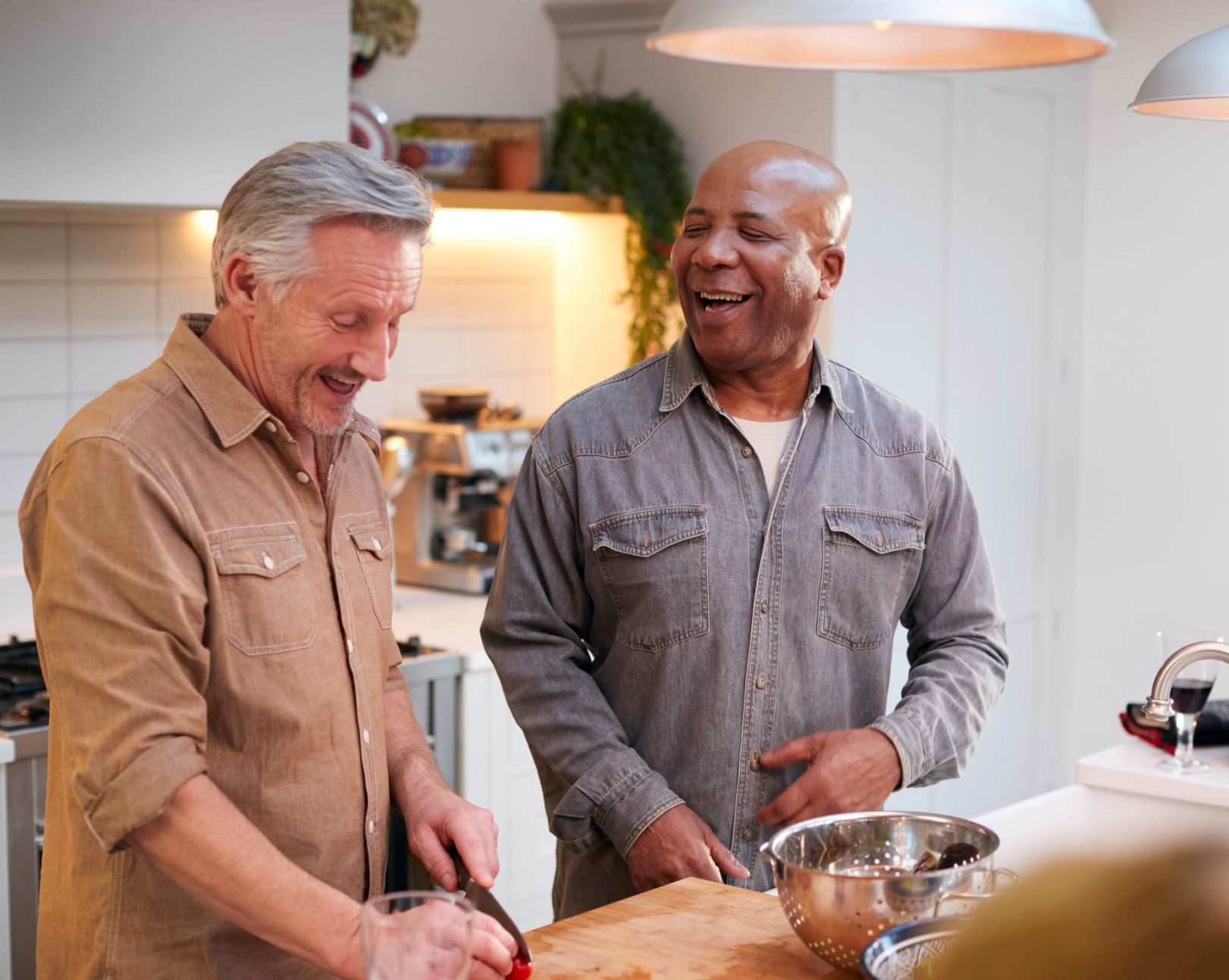 Two men laughing and cooking together in a beautiful kitchen
